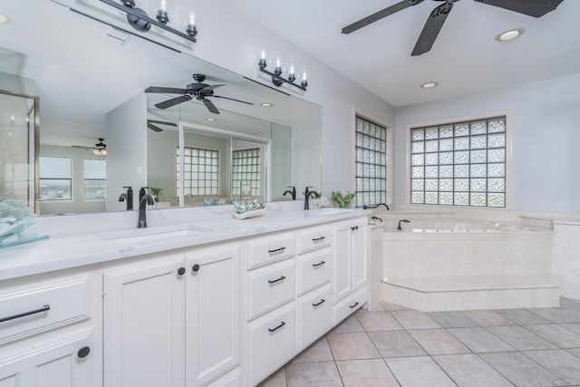 full bath with tile patterned floors, a garden tub, double vanity, and a sink