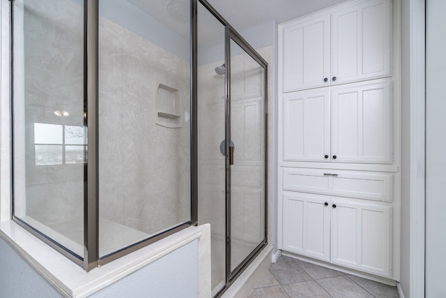 bathroom featuring tile patterned flooring and a stall shower