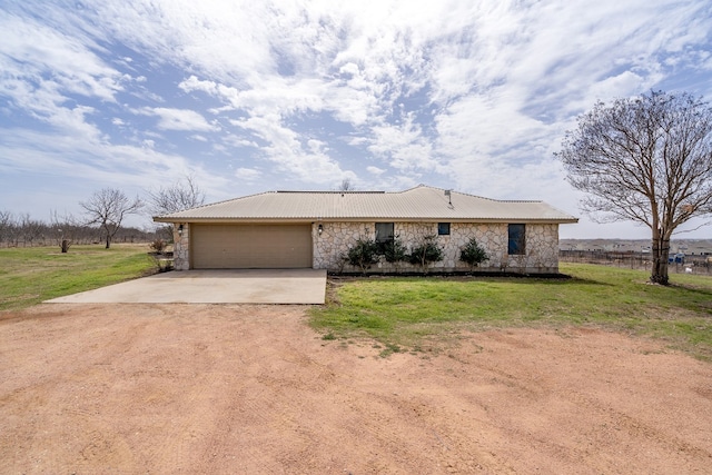 single story home featuring stone siding, driveway, an attached garage, and a front yard