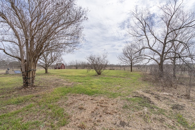 view of yard with a rural view and an outdoor structure