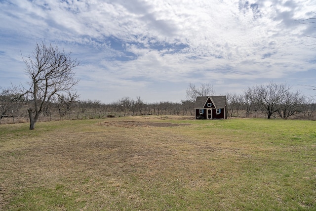 view of yard featuring a rural view and an outdoor structure