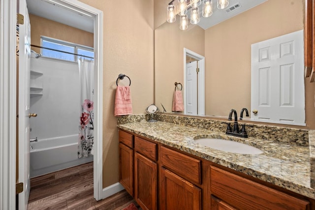 bathroom featuring visible vents, shower / bathtub combination with curtain, vanity, and wood finished floors