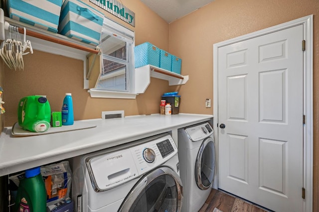 clothes washing area with washing machine and clothes dryer, laundry area, and wood finished floors