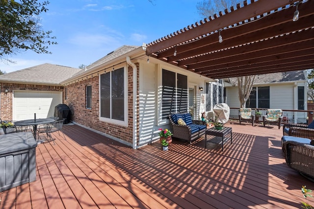 deck with area for grilling, an attached garage, and a pergola