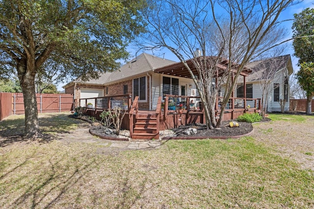 back of house with a yard, a deck, brick siding, and a fenced backyard