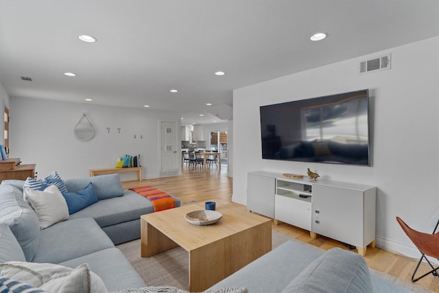 living area with recessed lighting, visible vents, and light wood finished floors