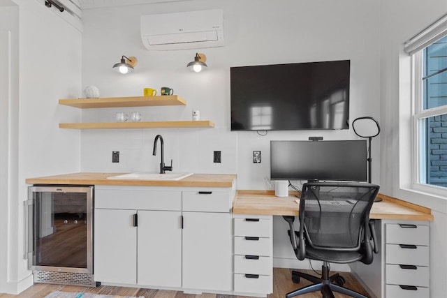 office space with a sink, wine cooler, light wood finished floors, and a wall mounted AC