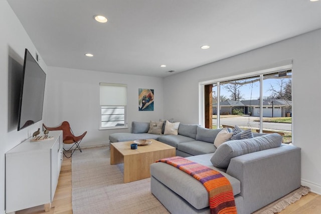 living room featuring a wealth of natural light, recessed lighting, and light wood finished floors