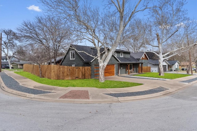 view of front of house featuring fence, a residential view, concrete driveway, a shingled roof, and a garage