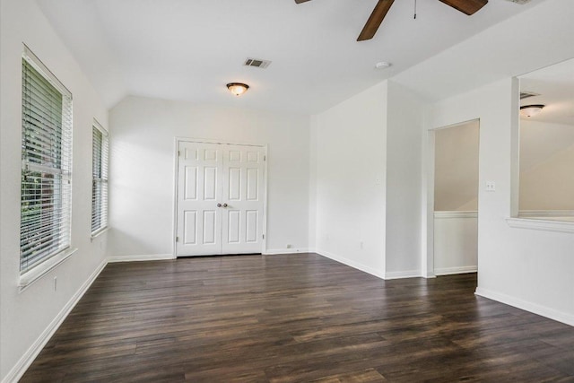 spare room featuring visible vents, baseboards, dark wood-style floors, and a ceiling fan