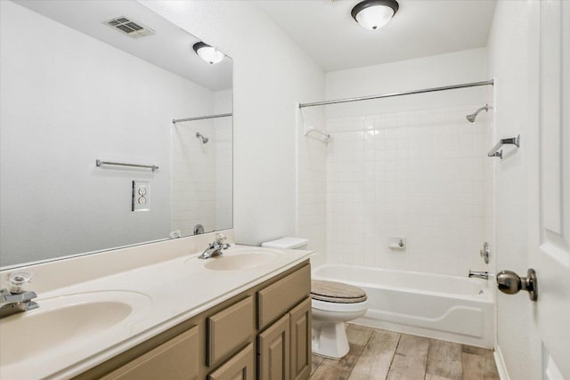 full bathroom featuring a sink, visible vents, toilet, and wood finished floors