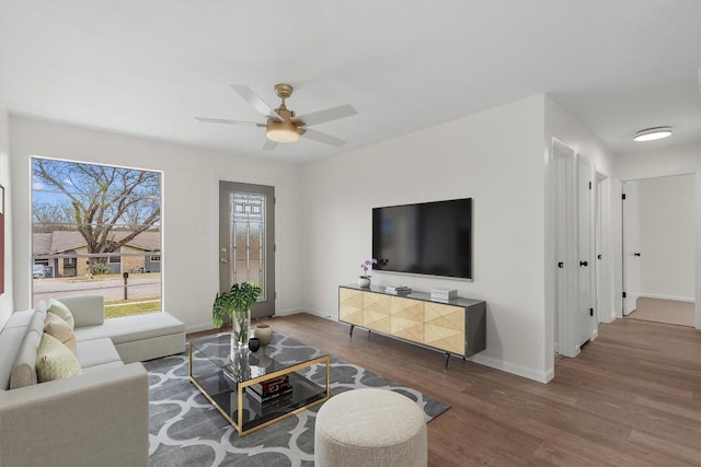 living room featuring a ceiling fan, wood finished floors, and baseboards