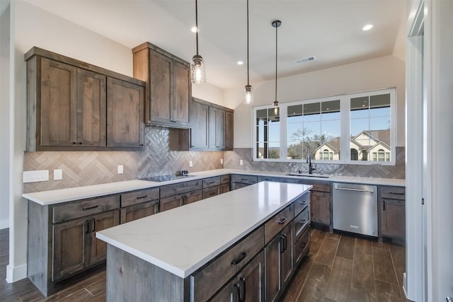 kitchen with visible vents, wood finish floors, a sink, dishwasher, and backsplash