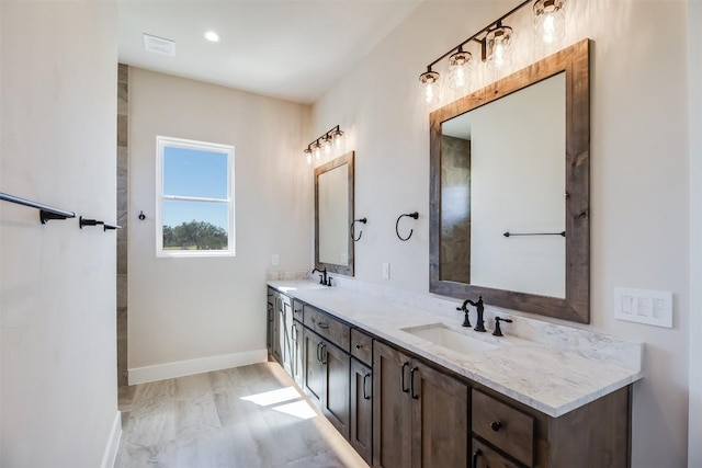 bathroom featuring double vanity, baseboards, and a sink