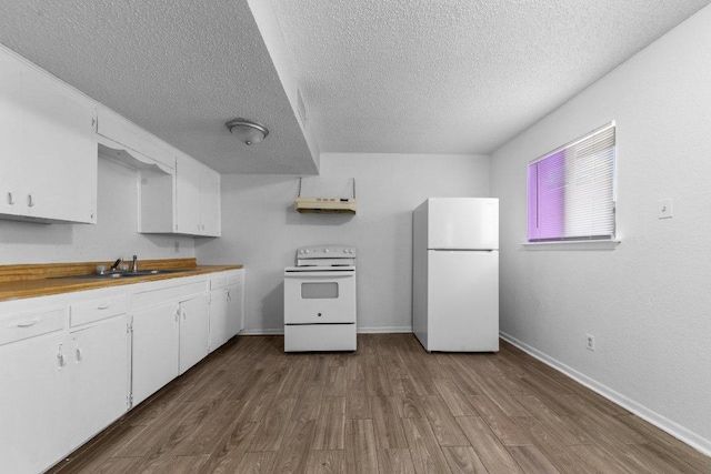 kitchen featuring white appliances, white cabinets, dark wood-style floors, and a sink