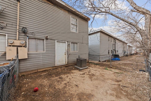 back of property featuring cooling unit and fence