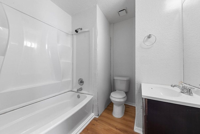 bathroom with visible vents, toilet, wood finished floors, a textured ceiling, and  shower combination