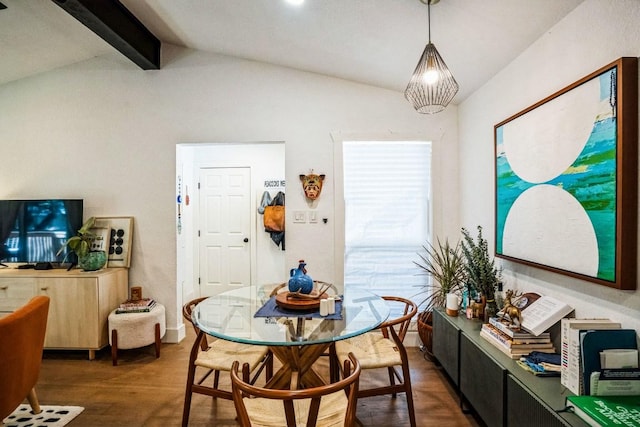 dining room featuring wood finished floors and vaulted ceiling with beams