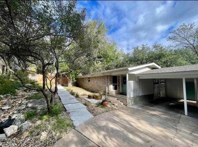 view of home's exterior featuring an attached carport and driveway