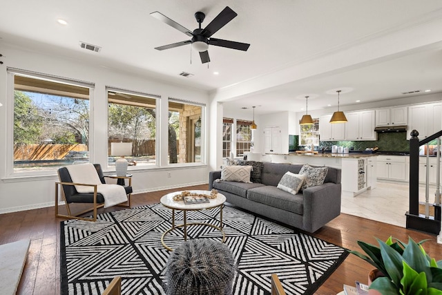 living area with visible vents, light wood-style flooring, a ceiling fan, recessed lighting, and baseboards