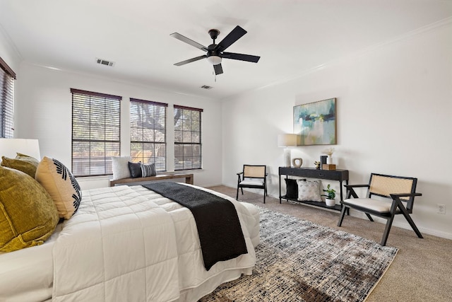 carpeted bedroom with visible vents, baseboards, a ceiling fan, and crown molding