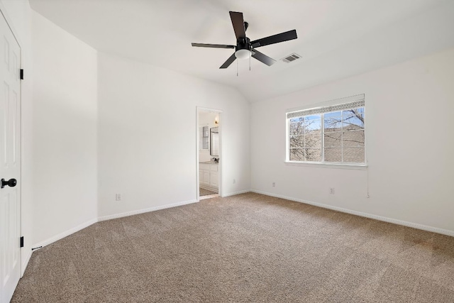 unfurnished bedroom with baseboards, visible vents, vaulted ceiling, ensuite bathroom, and carpet flooring