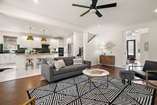 living area featuring recessed lighting, stairway, crown molding, baseboards, and dark wood-style flooring