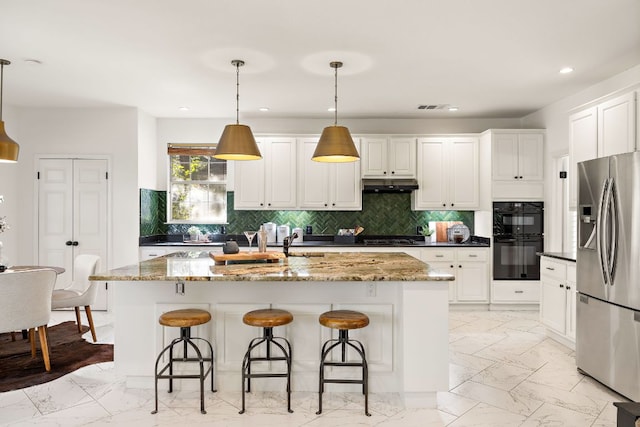 kitchen with under cabinet range hood, stainless steel fridge, marble finish floor, and dobule oven black