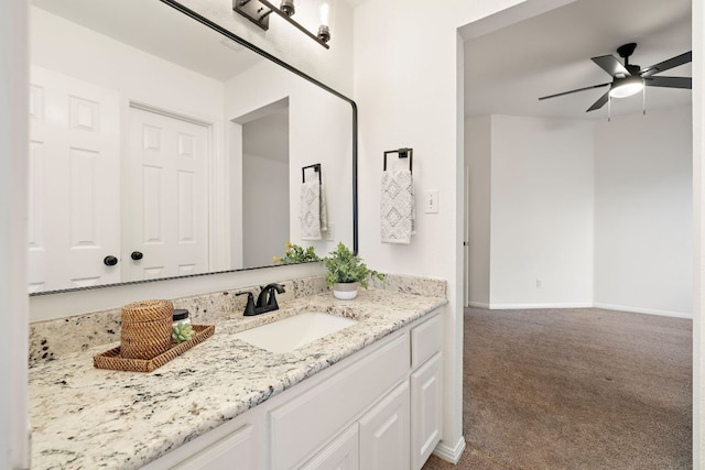 bathroom with baseboards, vanity, and a ceiling fan