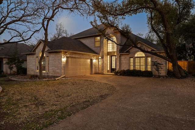 view of front facade featuring a garage, stone siding, and driveway