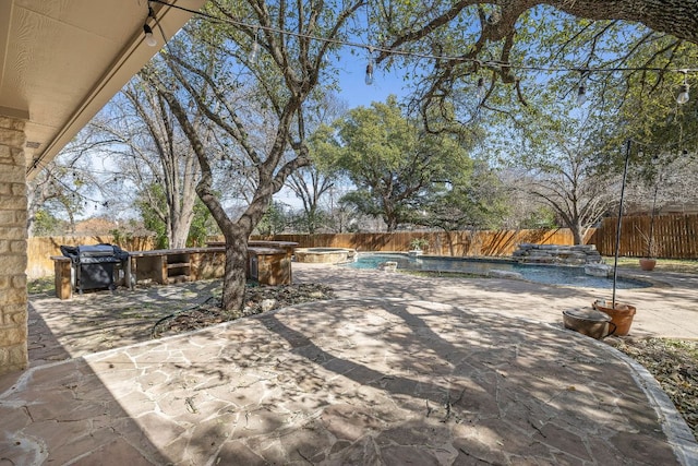 view of patio / terrace with a grill, a fenced backyard, and a pool with connected hot tub