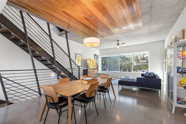 dining space featuring concrete floors and stairs