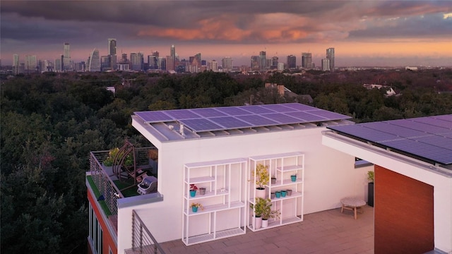 view of outbuilding with solar panels and a city view