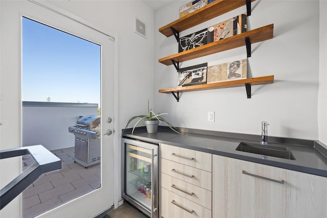 bar with a sink, visible vents, beverage cooler, and indoor wet bar