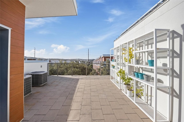 view of patio with cooling unit and a balcony