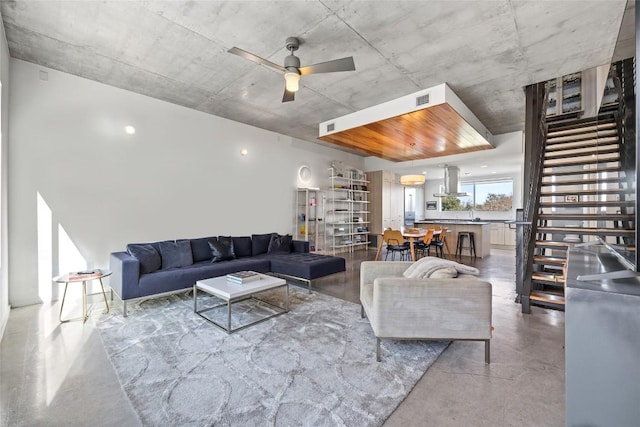 2301 S 5th St Unit 25, Austin, TX 78704 - living room featuring finished concrete flooring, ceiling fan, and stairs