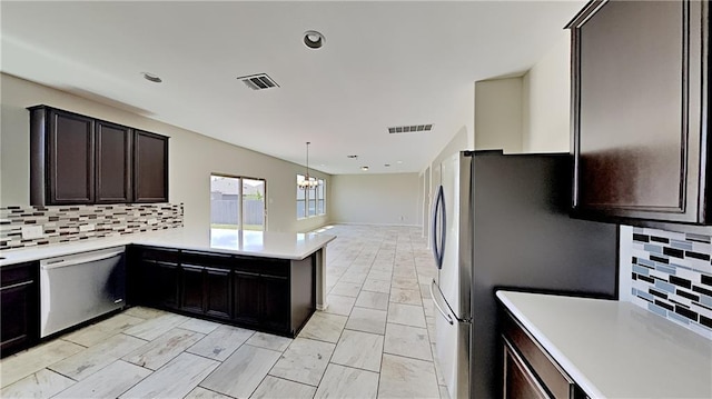 kitchen featuring light countertops, visible vents, backsplash, and stainless steel appliances