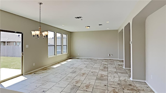 spare room with visible vents, baseboards, and an inviting chandelier