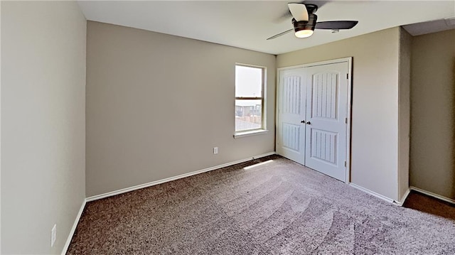 unfurnished bedroom with a closet, baseboards, ceiling fan, and carpet flooring