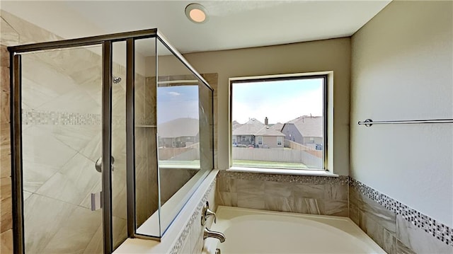 bathroom featuring a garden tub and a stall shower