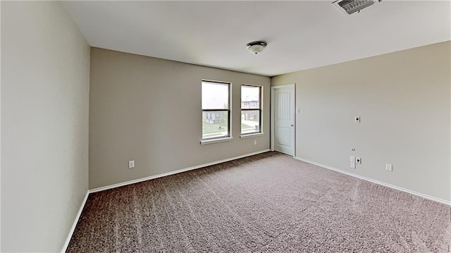 spare room with visible vents, carpet floors, and baseboards