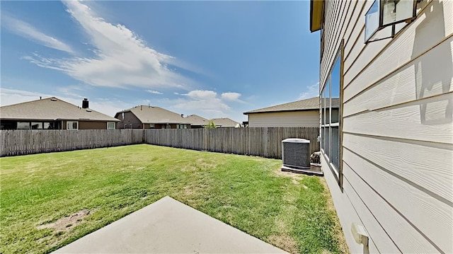 view of yard with central air condition unit, a residential view, and a fenced backyard