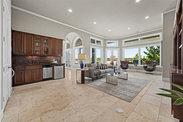 711 Cutlass, Lakeway, TX 78734 - living room with stone tile flooring, crown molding, recessed lighting, arched walkways, and bar