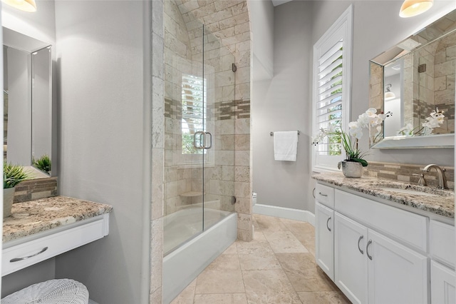 bathroom with vanity, toilet, baseboards, and shower / bath combination with glass door