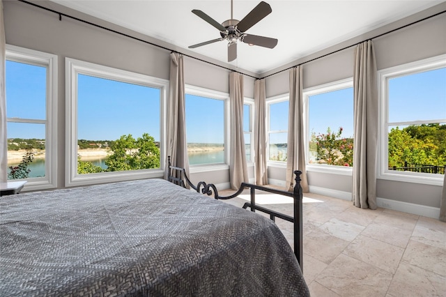 711 Cutlass, Lakeway, TX 78734 - bedroom with multiple windows, stone tile floors, a water view, and ceiling fan