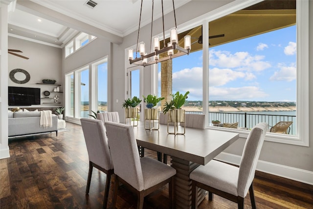 dining room featuring baseboards, dark wood finished floors, a high ceiling, a water view, and crown molding