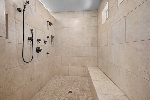 bathroom with a tile shower and mail area