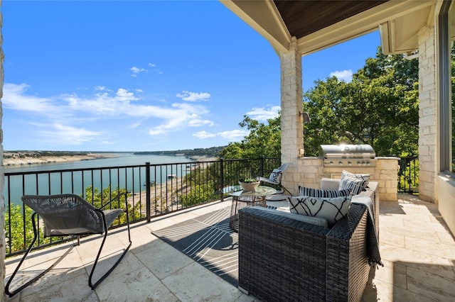 view of patio with an outdoor living space, grilling area, an outdoor kitchen, and a water view