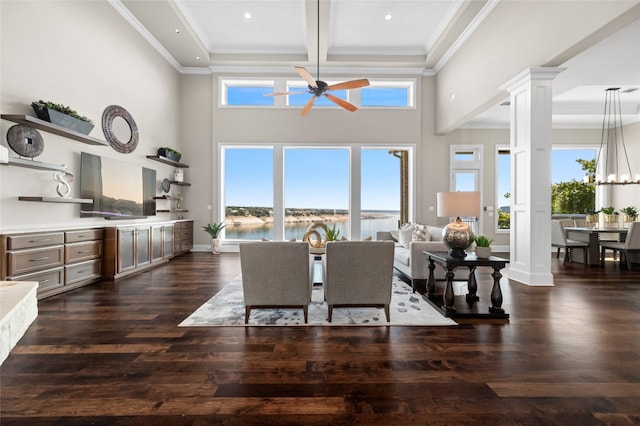 dining room with a ceiling fan, decorative columns, dark wood-type flooring, crown molding, and beamed ceiling