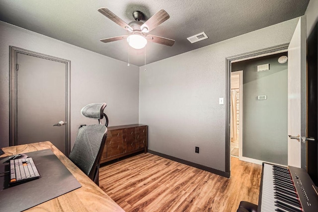 office area featuring visible vents, a textured ceiling, wood finished floors, and a ceiling fan